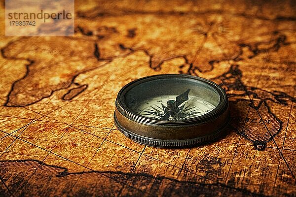 Old vintage retro Kompass auf alten Weltkarte close up