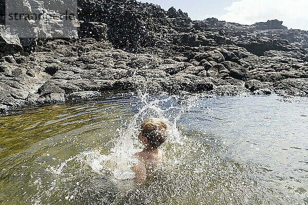 Kleiner Junge springt fröhlich in den natürlichen Pools von Charcones auf Lanzarote  Kanarische Inseln  Spanien  Europa