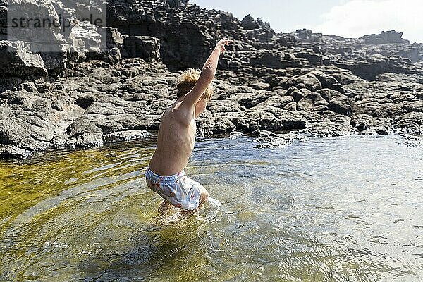 Kleiner Junge springt fröhlich in den natürlichen Pools von Charcones auf Lanzarote  Kanarische Inseln  Spanien  Europa