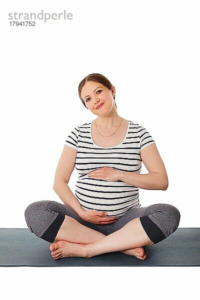 Schwangerschaft Yoga-Übung  schwangere Frau tut asana Sukhasana einfache Yoga-Pose umarmt ihren Bauch vor weißem Hintergrund