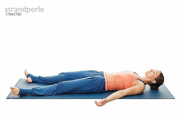 Frau entspannt in Yoga-Asana Savasana  Leichenstellung vor weißem Hintergrund