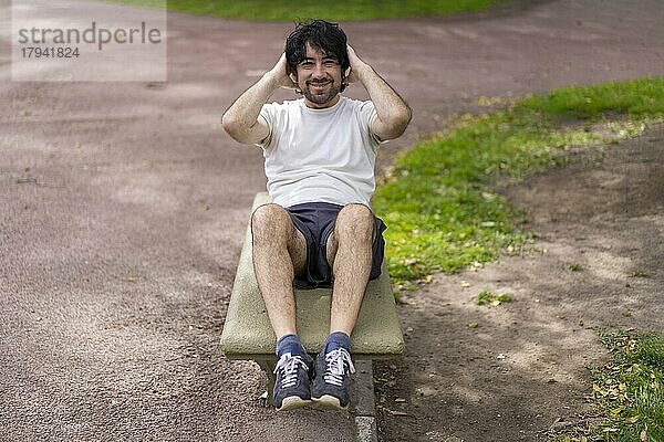 Porträt von gut aussehend attraktiv reifen bärtigen sportlichen lateinischen Mann Kerl 40s tun Sit-ups im Park