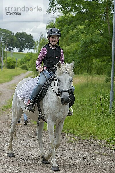 Lachendes Mädchen  10 Jahre  reitet auf einem Pferd  Mecklenburg-Vorpommern  Deutschland  Europa