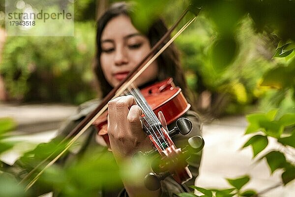 Mädchen mit ihrer Geige spielt eine Melodie im Freien  Konzept der lächelnden Geigerin. Attraktives Mädchen spielt Geige im Freien. Porträt eines Mädchens  das im Freien Geige spielt