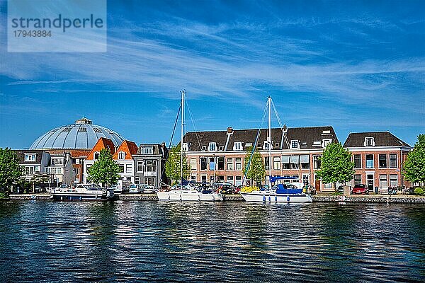 Boote und Häuser auf dem Fluss Spaarne mit blauem Himmel. Haarlem  Niederlande  Europa