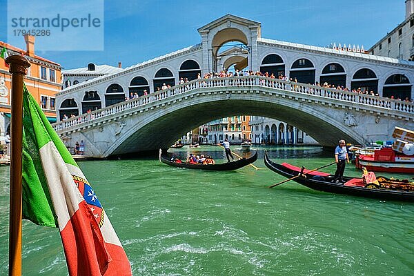 Italienische Seeflagge mit Rialto-Brücke mit Booten und Gondeln im Hintergrund. Canal Grande  Venedig  Italien  Europa