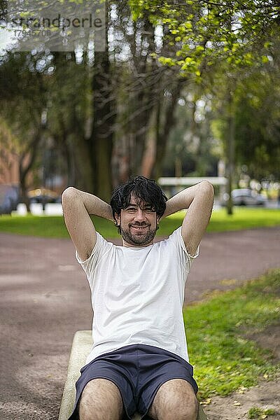 Porträt von gut aussehend attraktiv reifen bärtigen sportlichen lateinischen Mann Kerl 40s tun Sit-ups im Park