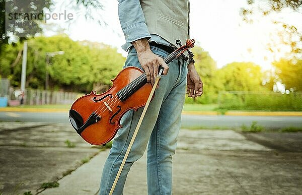 Hände halten Geige und Reifen im Freien  Nahaufnahme von Händen halten Geige und Reifen. Konzept der Person hält Geige und Reifen im Freien
