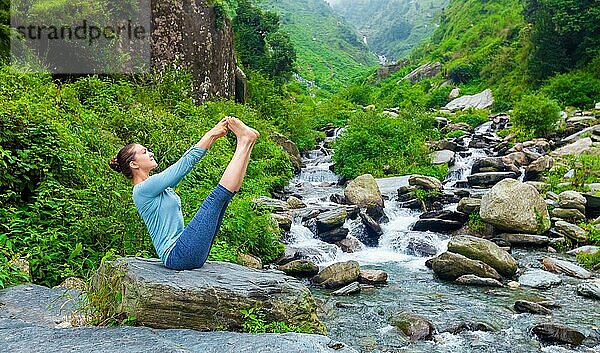 Yoga-Übung im Freien  Panorama der Frau tun Ashtanga Vinyasa Yoga Gleichgewicht asana Ubhaya padangusthasana Big Double Toe Yoga Pose an tropischen Wasserfall im Himalaya in Indien. Panoramabild