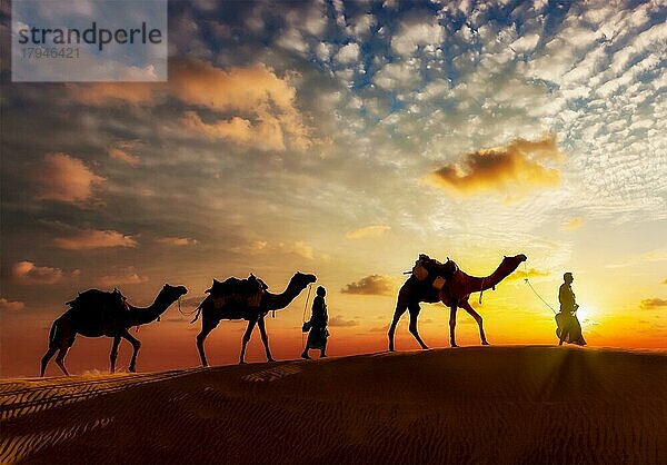 Reise-Hintergrund  zwei Kamele (Kameltreiber) mit Kamelen Silhouetten in den Dünen der Wüste bei Sonnenuntergang