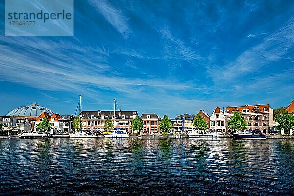 Boote und Häuser auf dem Fluss Spaarne mit blauem Himmel. Haarlem  Niederlande  Europa