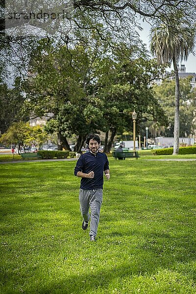 Porträt von gut aussehend attraktiv reifen bärtigen sportlichen lateinischen Mann Kerl 40s in lässigen blauen T-Shirt läuft in einem Park
