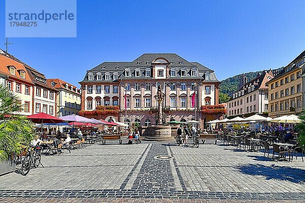 Heidelberg  Deutschland  Historisches Rathaus am Marktplatz mit Brunnen und Statue davor und Menschen in Cafés im Freien an einem warmen sonnigen Tag  Europa