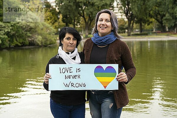 Liebe ist nie falsch  Fröhliches queeres Paar mit einer Botschaft zur Unterstützung der LGBT Gemeinschaft