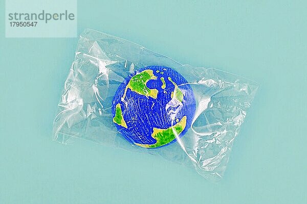 Kleines Modell des Planeten Erde in Plastik eingewickelt
