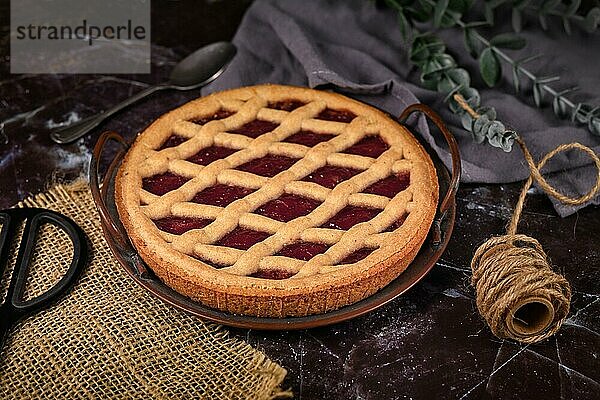 Hausgemachte Linzer Torte  ein traditionelles österreichisches Mürbeteiggebäck  belegt mit eingemachten Früchten und gehackten Nüssen mit Gittermuster