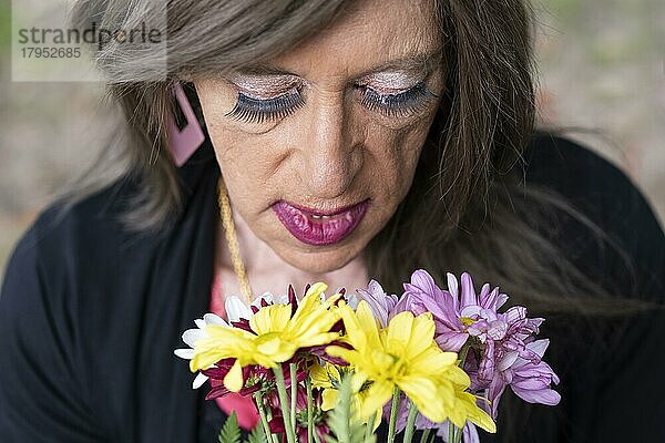 Porträt einer reifen Transgender-Frau mit einem Blumenstrauß von oben gesehen