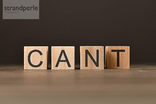 Erfolgskonzept und Herausforderungen mit Holzwürfeln  die das Wort CANT mit dem Buchstaben T auf der Rückseite buchstabieren