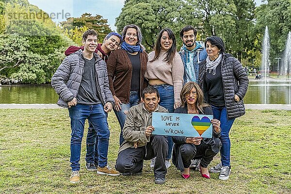 Fröhliche queere Gruppe mit einer Botschaft zur Unterstützung der LGBT Gemeinschaft