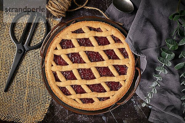 Draufsicht auf die hausgemachte Linzer Torte  ein traditionelles österreichisches Mürbeteiggebäck mit eingemachten Früchten und gehackten Nüssen mit Gittermuster