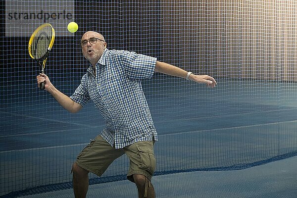 Senior spielt Tennis in der Halle