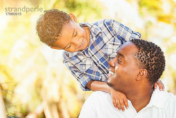 Gemischtrassiger sohn und afroamerikanischer vater spielen zusammen im freien