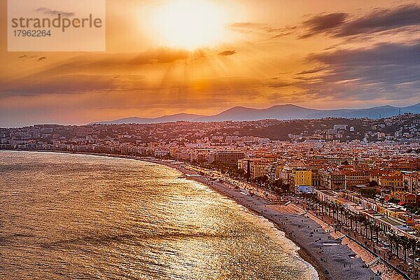 Malerische Ansicht von Nizza  Frankreich bei Sonnenuntergang  Mittelmeerwellen  die an den Strand schwappen  Menschen entspannen sich am Strand  Autos fahren auf der Straße  Nizza  Frankreich  Europa