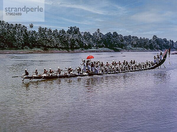 Die farbenfrohen Regenschirme  die von Männern in ihrer traditionellen Kleidung während des Aranmula-Bootsrennens in den Booten mitgeführt werden  Kerala  Indien  Asien