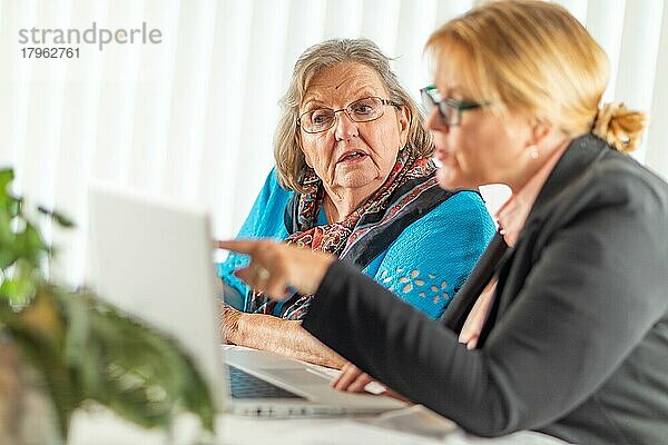 Frau hilft älterer erwachsener Dame am Laptop-Computer