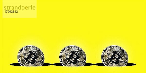 Virtuelle Kryptowährung Konzept  drei Bitcoin Münzen auf gelbem Hintergrund mit Textfreiraum