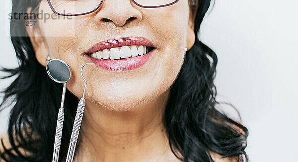 Close up von perfekten Lächeln und Zahnarzt Werkzeuge auf weißem Hintergrund  Perfektes Lächeln der Frau mit Zahnarzt Werkzeuge  Konzept der perfekten Lächeln und Zahnarzt Werkzeuge