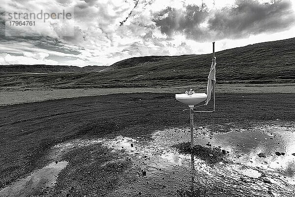 Freistehendes Waschbecken mit Handtuch  Körperpflege im Freien  Schotterplatz in der Nähe des Vulkans Krafla  Gegenlicht  Myvatn  Nordisland  Island  Europa