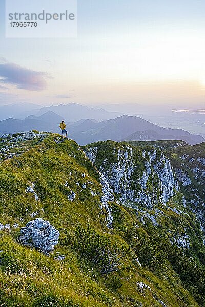 Wanderer am Gipfel der Benediktenwand bei Sonnenuntergang  hinten Silhouetten von Bergen  Bayerische Voralpen  Bayern  Deutschland  Europa