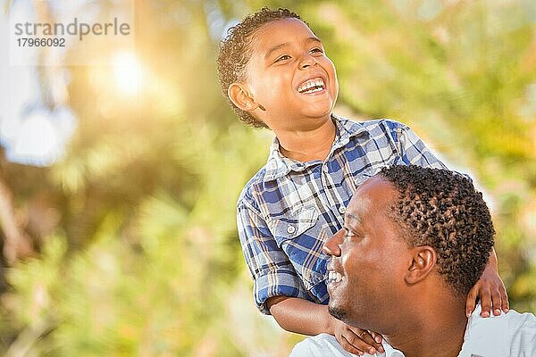 Gemischtrassiger sohn und afroamerikanischer vater spielen zusammen im freien