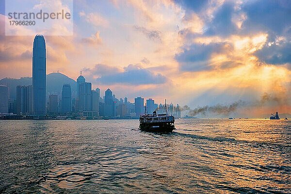 Hong Kong Skyline Stadtbild Downtown Wolkenkratzer über Victoria Harbour auf Sonnenuntergang mit Touristen Fähre Boot Silhouette. Hongkong  China  Asien