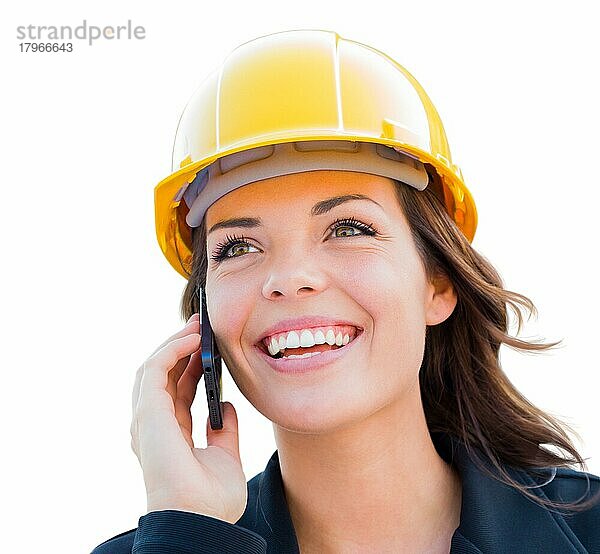 Female contractor in hard hat using cell phone before white
