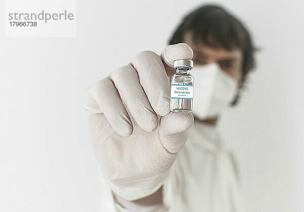 Arzt mit Impfstoffflasche und Spritze  Beginn der weltweiten Massenimpfung gegen das Coronavirus COVID-19  Influenza oder Grippe  Welt-Immunisierungskonzept. Selektiver Fokus