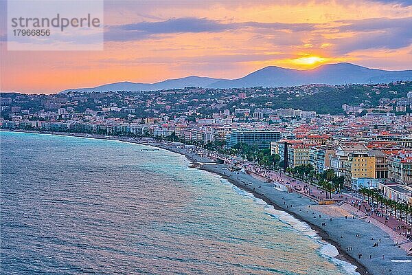 Malerische Ansicht von Nizza  Frankreich bei Sonnenuntergang  Mittelmeerwellen  die an den Strand schwappen  Menschen entspannen sich am Strand  Autos fahren auf der Straße  Nizza  Frankreich  Europa