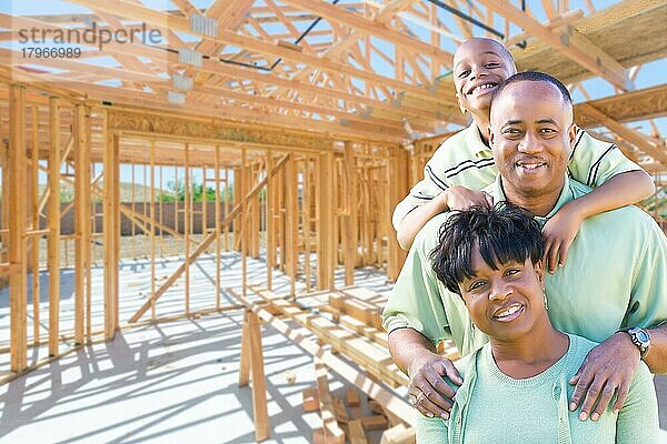 Junge afroamerikanische Familie auf der Baustelle in ihrem neuen Haus  das im Rohbau steht