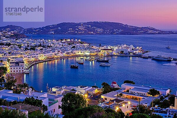 Blick auf Mykonos Chora Stadt griechischen Touristen Urlaub Urlaubsziel mit berühmten Windmühlen  und Hafen mit Booten und Yachten in den Abend beleuchtet blaue Stunde  Mykonos  Kykladen-Inseln  Griechenland  Europa