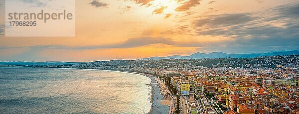 Malerisches Panorama von Nizza  Frankreich bei Sonnenuntergang  Wellen des Mittelmeeres schlagen an den Strand  Menschen entspannen sich am Strand  Autos fahren auf der Straße  Nizza  Frankreich  Europa