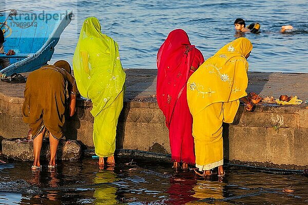 Indische Frauen bei der morgendlichen Pooja an den Ghats des heiligen Flusses Narmada. Maheshwar  Madhya Pradesh  Indien  Asien