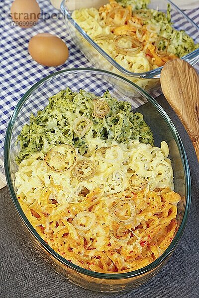 Schwäbische Küche  Spätzle-Auflauf  dreierlei Spätzle mit Käse überbacken  Spätzle klassisch  mit Spinat und mit roter Paprika  Mehlspeise  geschmälzte Zwiebelringe  Eier  Holzkochlöffel  Rührlöffel  typisch Schwäbisch  handgeschabte Spätzle  aus dem Ofen  Auflaufform  Traditionsküche  vegetarisch  Foodfotografie  Studio  Deutschland  Europa