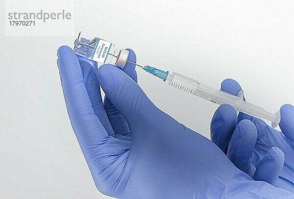 Ein Arzt hält eine Impfstoffflasche und eine Spritze  Beginn der weltweiten Massenimpfung gegen das Coronavirus COVID-19  Influenza oder Grippe  Welt-Immunisierungskonzept. Selektiver Fokus
