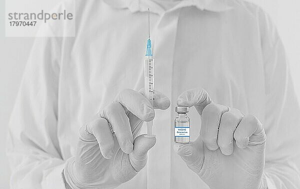 Ein Arzt hält eine Impfstoffflasche und eine Spritze  Beginn der weltweiten Massenimpfung gegen das Coronavirus COVID-19  Influenza oder Grippe  Welt-Immunisierungskonzept. Selektiver Fokus
