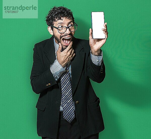 Geschäftsmann zeigt ein Handy von vorne  glücklicher Geschäftsmann zeigt sein Handy vor grünem Hintergrund