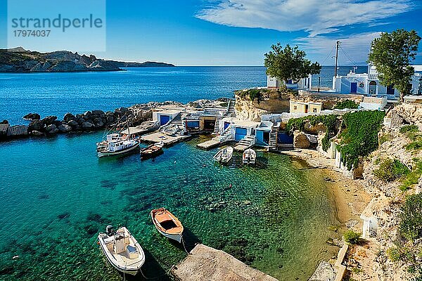 Typische griechische Inselansicht  kleiner Hafen mit Fischerbooten im kristallklaren türkisfarbenen Wasser  traditionelle weiße Häuser  Kirche. Mandrakia Dorf  Insel Milos  Griechenland  Europa