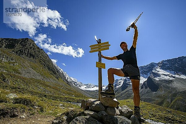 Bergsteiger an Wegemarkierung im Gegenlicht und Sellrainer Bergen im Hintergrund  Sellrain  Innsbruck  Tirol  Österreich  Europa