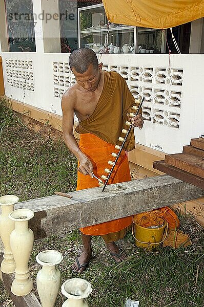 Buddhistischer Mönch putzt reinigt goldene Glöckchen in buddhistisches Kloster  Insel Koh Lanta  Thailand  Asien