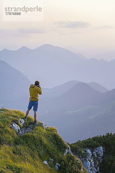 Fotograf fotografiert  Gipfel der Benediktenwand bei Sonnenuntergang  hinten Silhouetten von Bergen  Bayerische Voralpen  Bayern  Deutschland  Europa